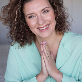 Anja lächelnd und mit Praying Hands Haltung.